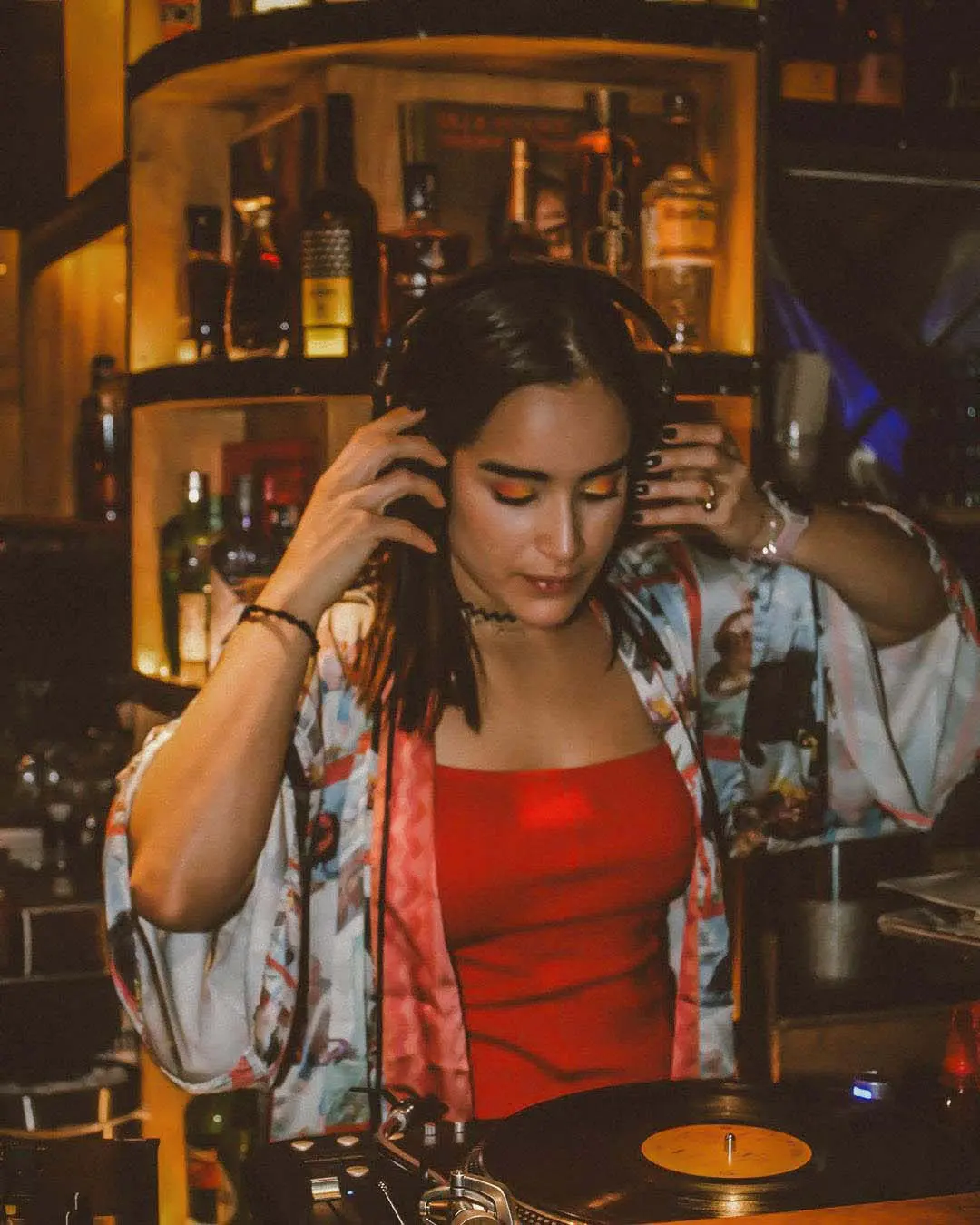 Intimate dining setting with a glass of wine, a lit red rose candle, and a plate of tacos